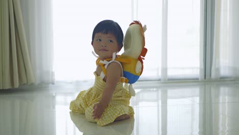 a baby girl explores her surroundings while harnessed for safety showcasing nurturing care.