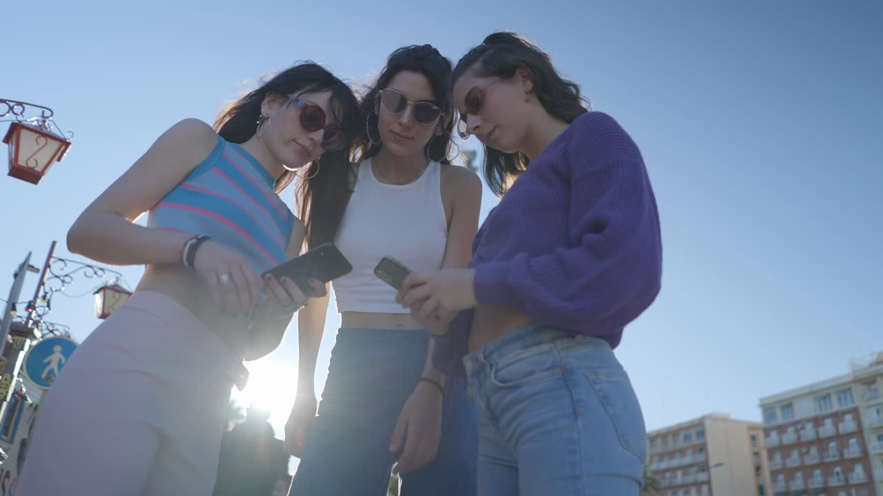 Three Young Women Looking at Smartphones