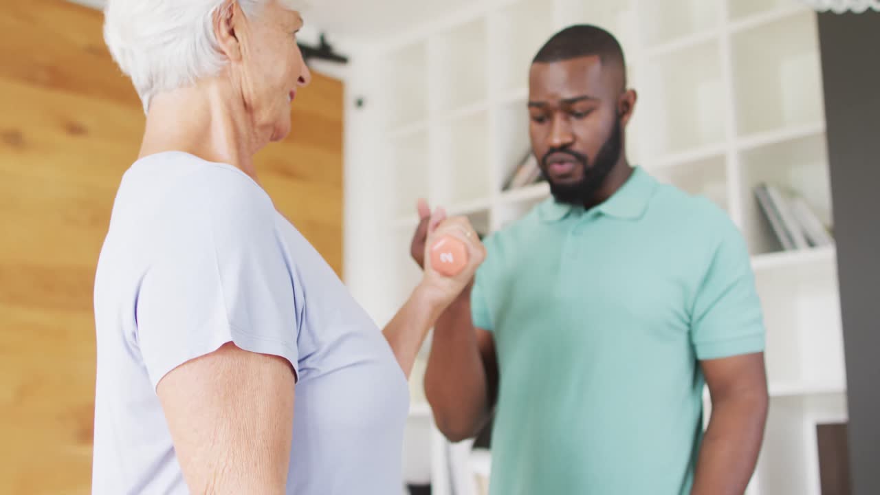 video de un fisioterapeuta afroamericano haciendo ejercicio con una mujer caucásica mayor