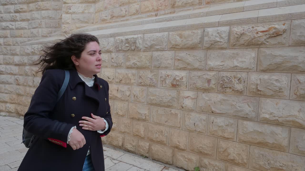 Tourist walks down a narrow alley in the old city of Jerusalem, Israel. Slow motion.