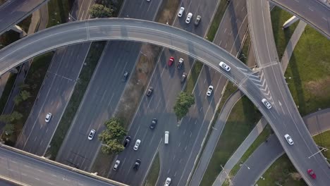 top down angle aerial drone view of elevated road and traffic junctions in chinese metropolis city chengdu during sunny day. modern construction design of traffic ways to avoid traffic jams, many cars