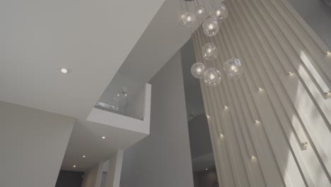 slow establishing shot of chandeliers hanging with a glass overhang in a house