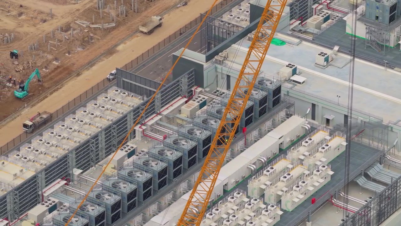 High angle view showcasing a hyperscale data center during its construction phase. The footage highlights the cooling systems and cranes