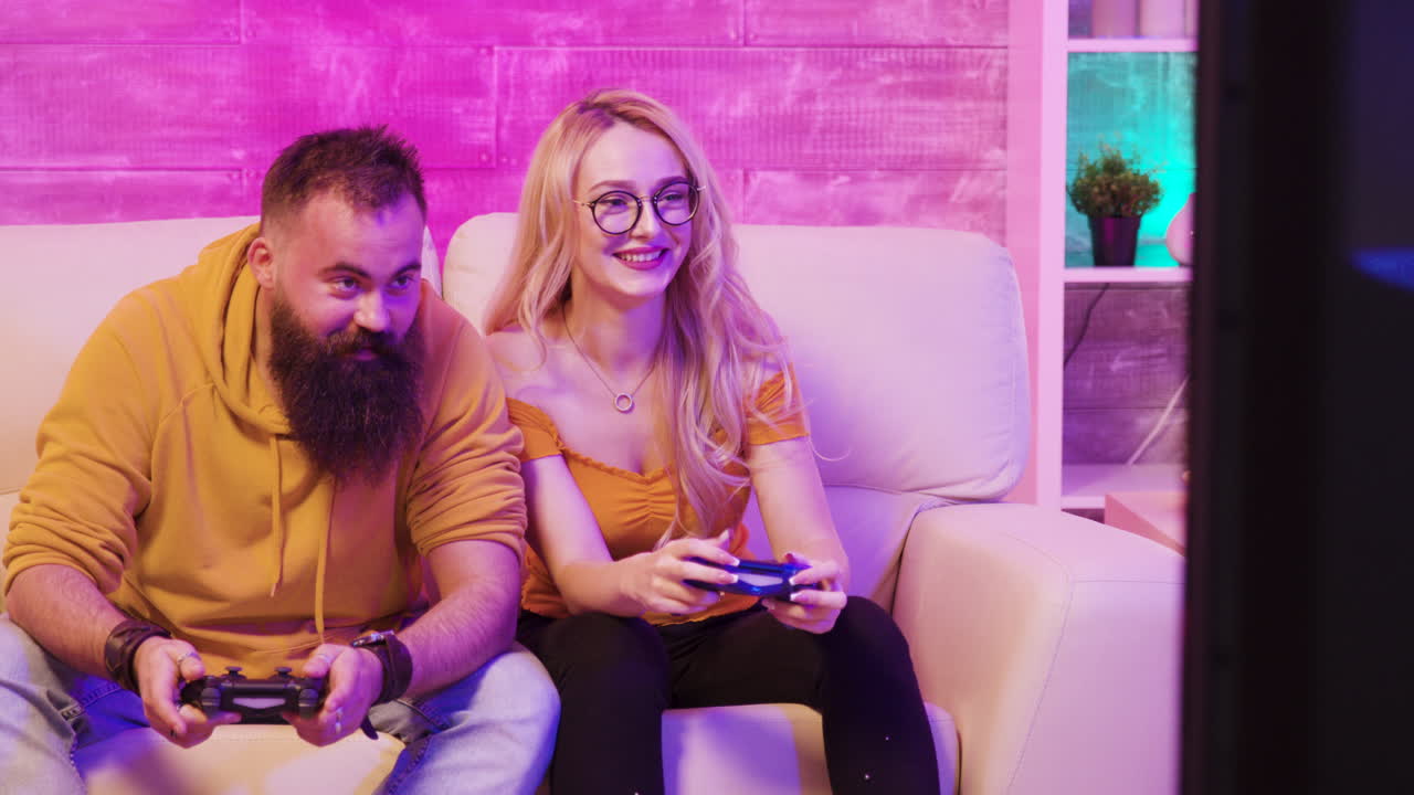 A couple playing video games together on a couch