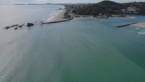 Surfers-At-The-Currumbin-Beach-On-The-Mouth-Of-Currumbin-Creek-In-Queensland,-Australia