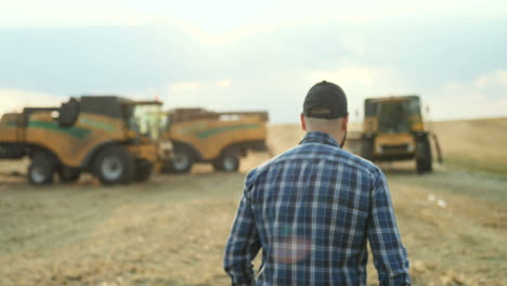 Back-view-of-man-wearing-a-blue-shirt-and-a-baseball-cap-and-walking-in-the-field