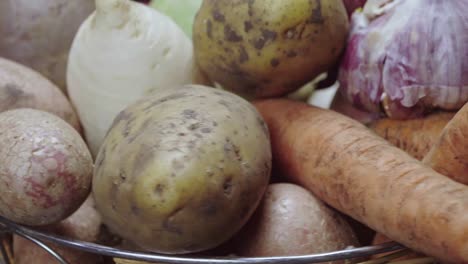 composition of vegetables, rotation of a basket with root vegetables, potatoes, beets, carrots and celery on a black background