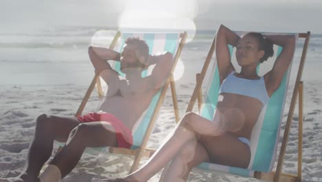 animación de puntos sobre una feliz pareja afroamericana acostada en camas de sol en la playa