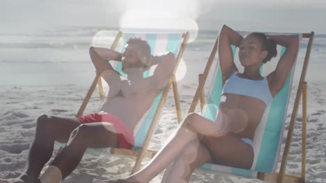 animation of dots over happy african american couple lying on sunbeds on beach