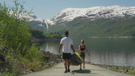 People-carry-a-kayak-to-a-scenic-lake-in-the-Norwegian-mountains