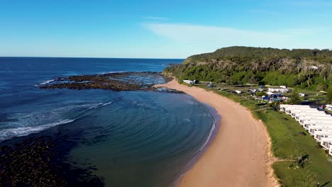 Drohnen-Luftschwenkaufnahme-Von-Shelly-Strandhütten-In-Der-Bateau-Bucht-Und-Buschland-Ozeanstrand-Reisetourismus-An-Der-Zentralküste-Von-New-South-Wales,-Australien-4k