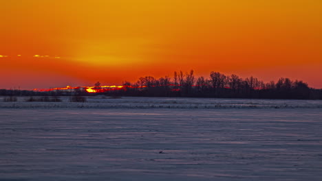 Blick-Auf-Die-Große-Sonne,-Die-Während-Des-Sonnenaufgangs-Während-Der-Wintersaison-über-Dem-Weißen-Schneefeld-über-Dem-Horizont-Aufgeht