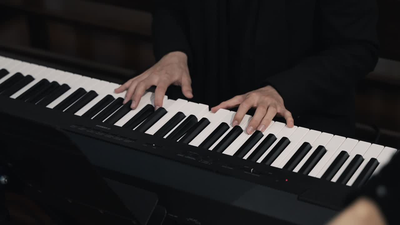 primer plano de las manos de un pianista tocando un teclado electrónico, centrándose en las teclas y los dedos