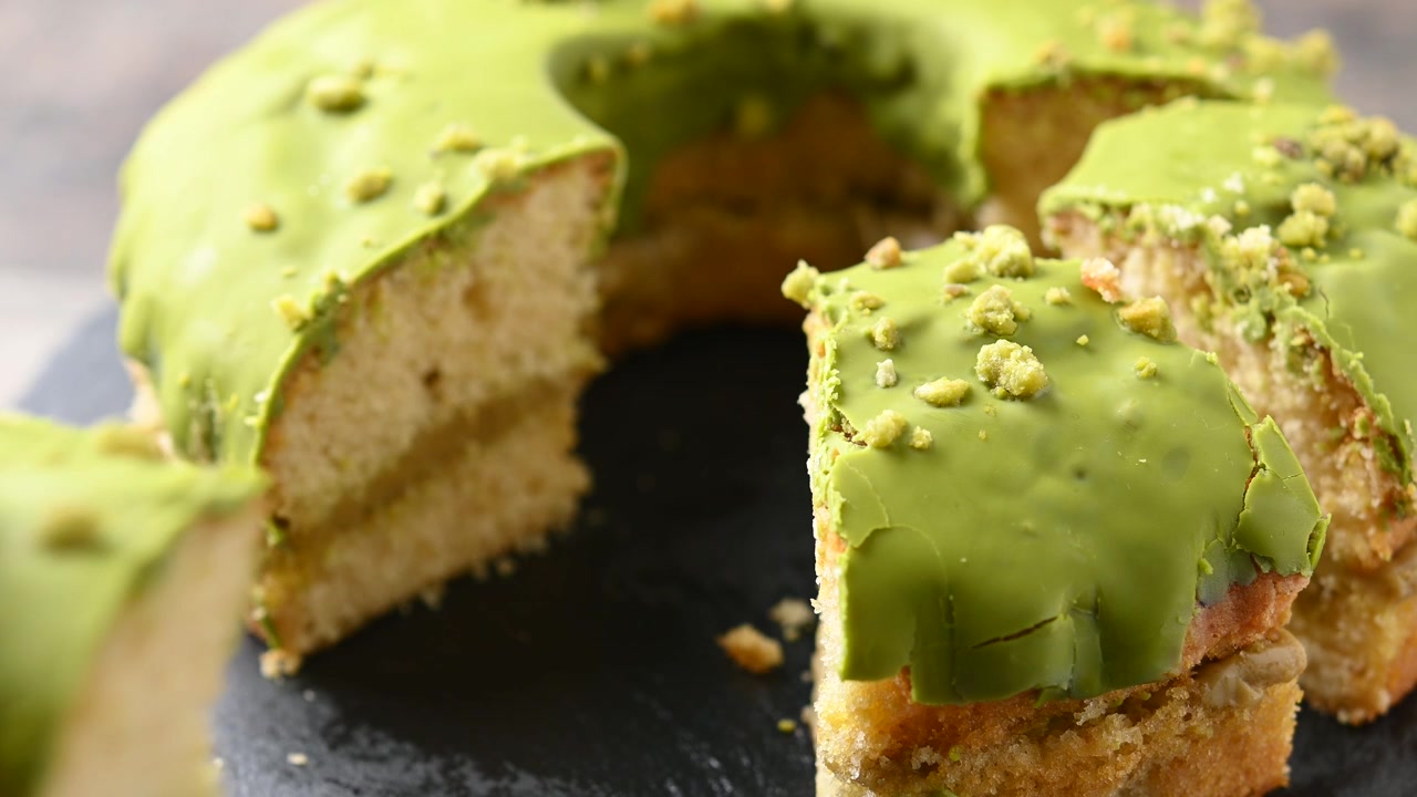 Hand taking a slice of pistachio bundt cake