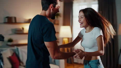 couple dancing and laughing while filming at home