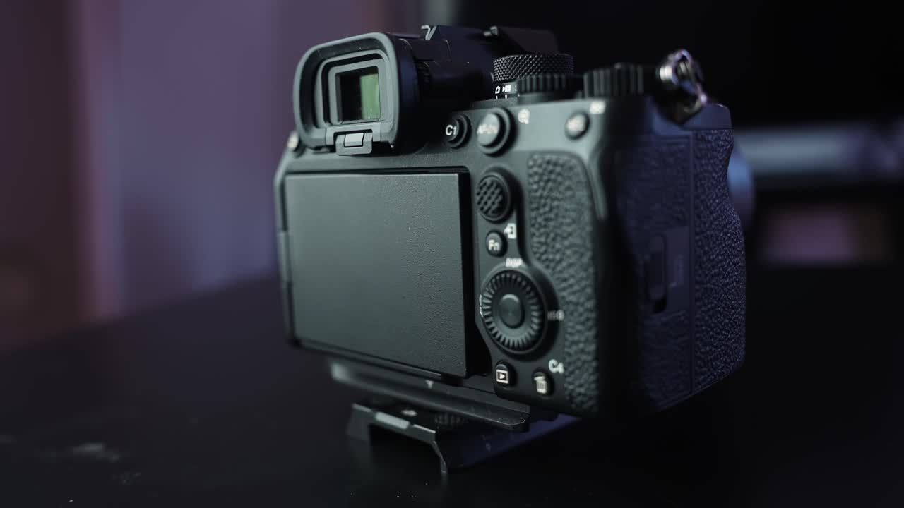 Close-up of a mirrorless camera mounted on a tripod with the LCD screen flipped outward toward the viewer in a studio environment, showcasing filming setup and content creation workflow