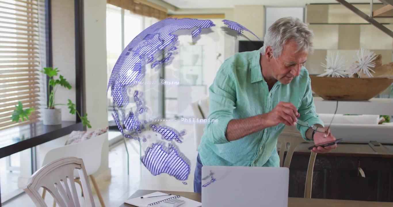Man lifting glasses and tapping smartphone while activating spinning globe on laptop for tech demo