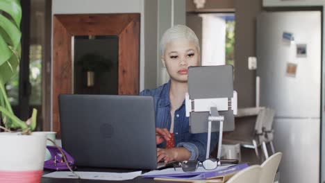 Mujer-Birracial-Ocupada-Trabajando-En-Casa-Con-Computadora-Portátil-Y-Tableta-En-Cámara-Lenta