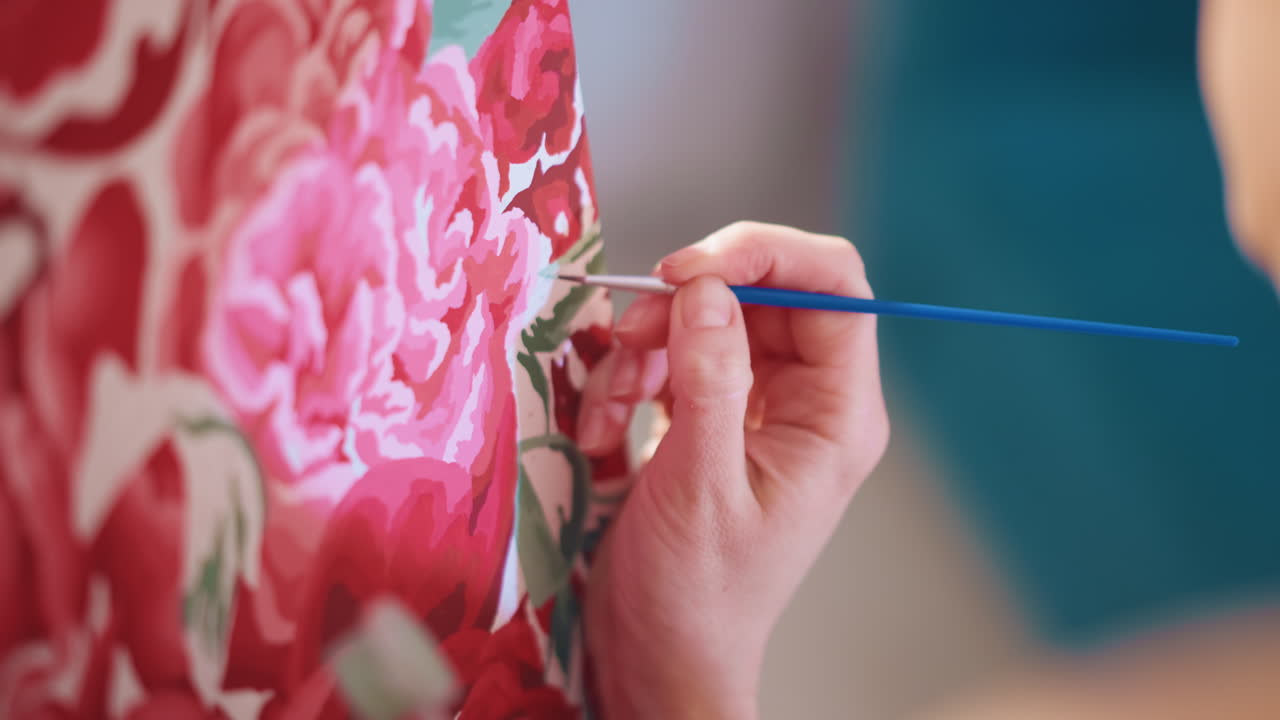Tecniche di pittura con petali rosa, dipinto di mani bianche che mescolano petali rosa con luce naturale, pennellate a strati creano un effetto botanico dettagliato su aree di lavoro usando luce naturale