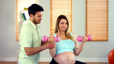 mujer embarazada haciendo ejercicio con el instructor