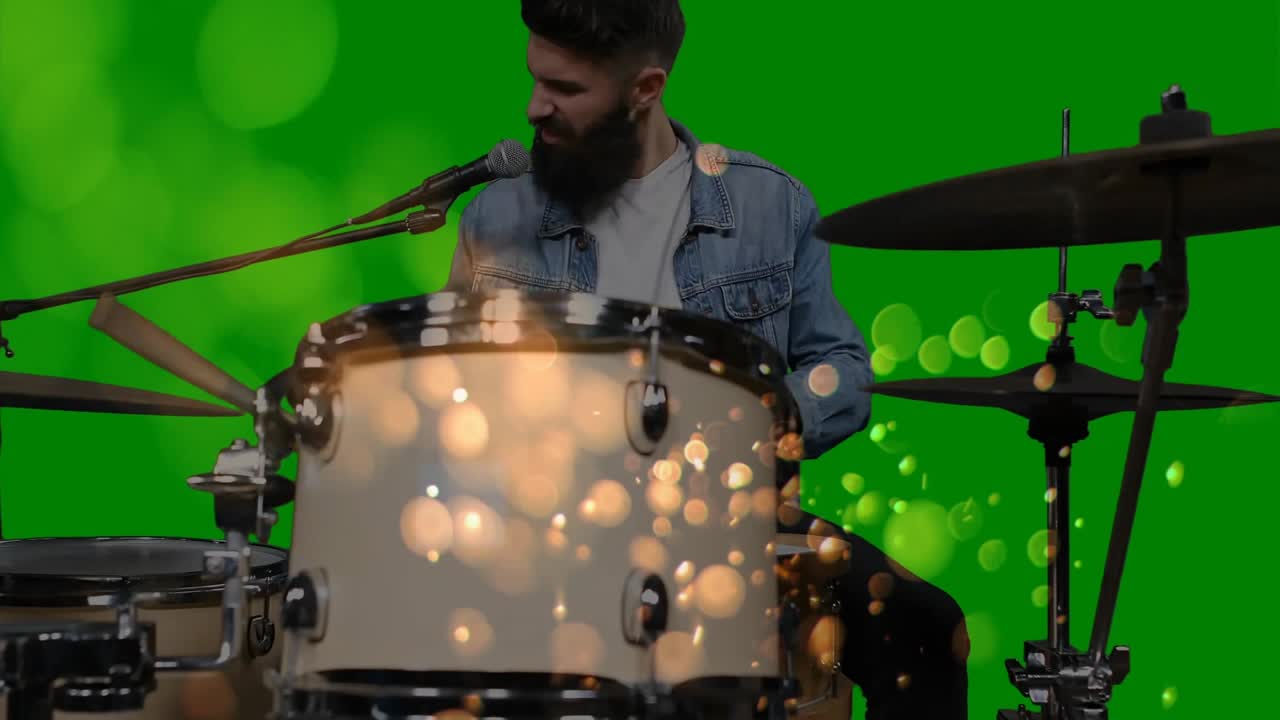 Sovrapposizione di effetto bokeh luminoso che si attiva su un batterista barbuto che suona tom e piatto ride per una registrazione musicale.