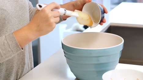 woman adding ingredients to bowl for baking