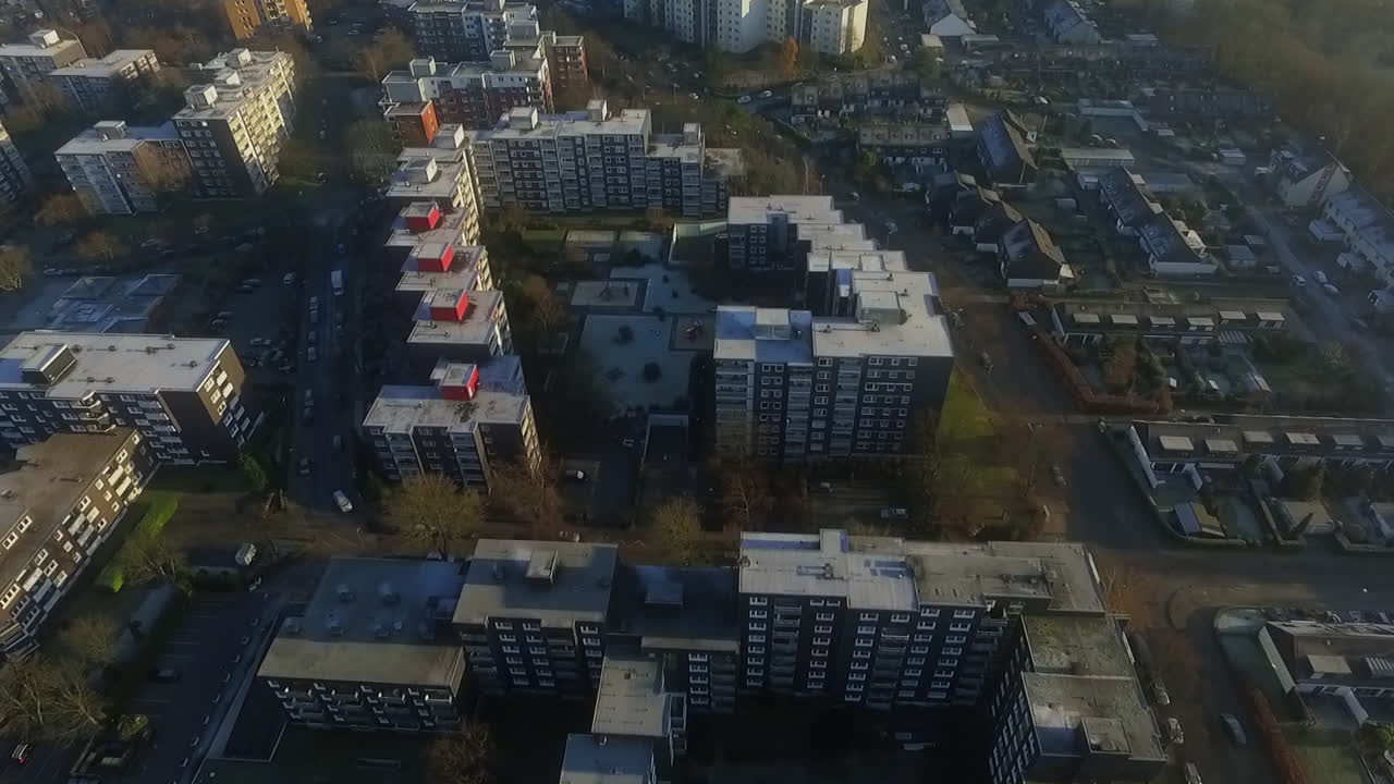 Avanços de drones em vista superior sobre edifícios residenciais e áreas de estacionamento ao nascer do sol na Alemanha