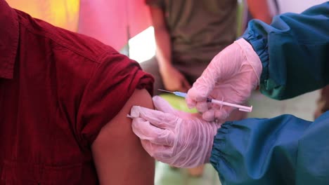 very-noise-and-film-grain-clip,-doctor-holding-syringe-and-using-cotton-before-make-injection-to-patient-in-medical-mask-Covid-19-or-coronavirus-vaccine