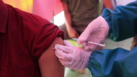 clip de grano de película y mucho ruido, médico sosteniendo una jeringa y usando algodón antes de inyectar al paciente con mascarilla médica covid-19 o vacuna contra el coronavirus