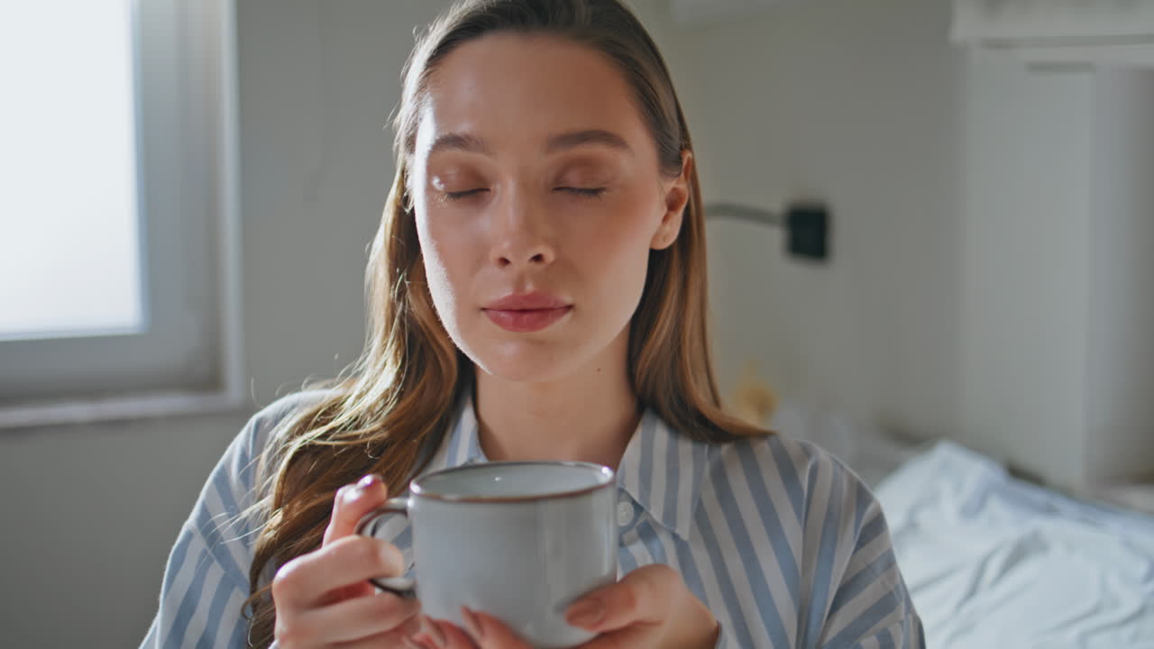 Relaxed girl enjoying tea in morning portraying serene enjoyment closeup