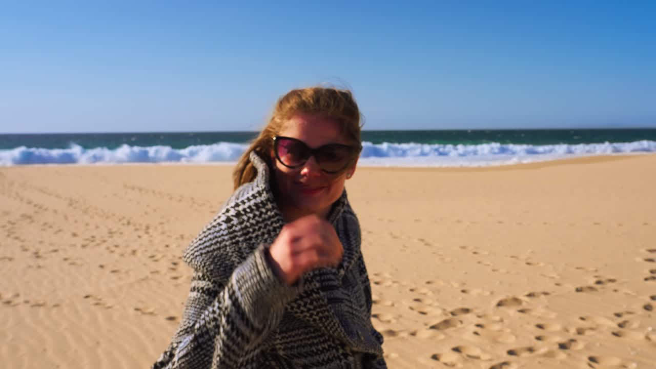 슬로우 모션으로 해변에서 카메라에 웃는 여자