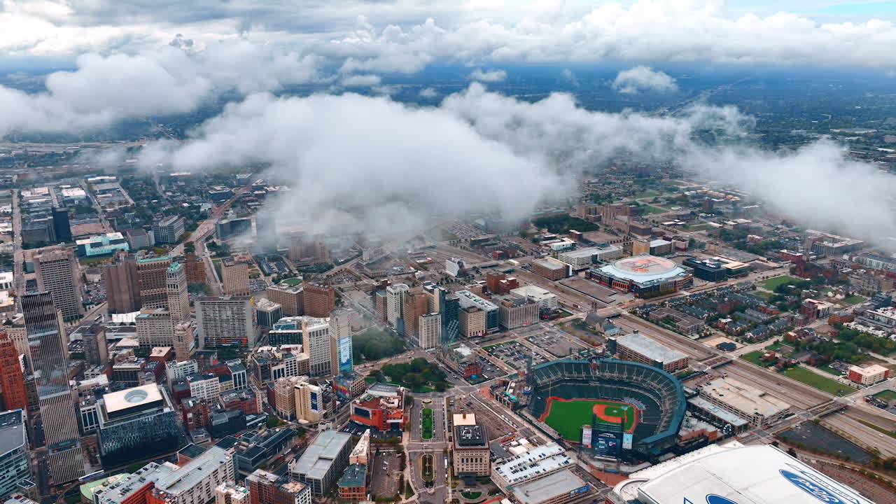 Detroit, USA, 28 July 2025: Detroit city skyline under low clouds. Foggy clouds drift above stadium roofs and central Detroit skyline