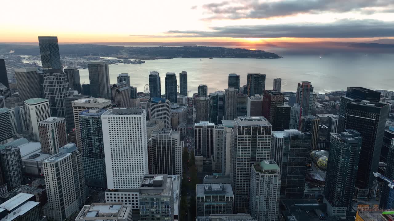 Aerial of Seattle skyline with sunlight peaking through clouds over Elliot Bay