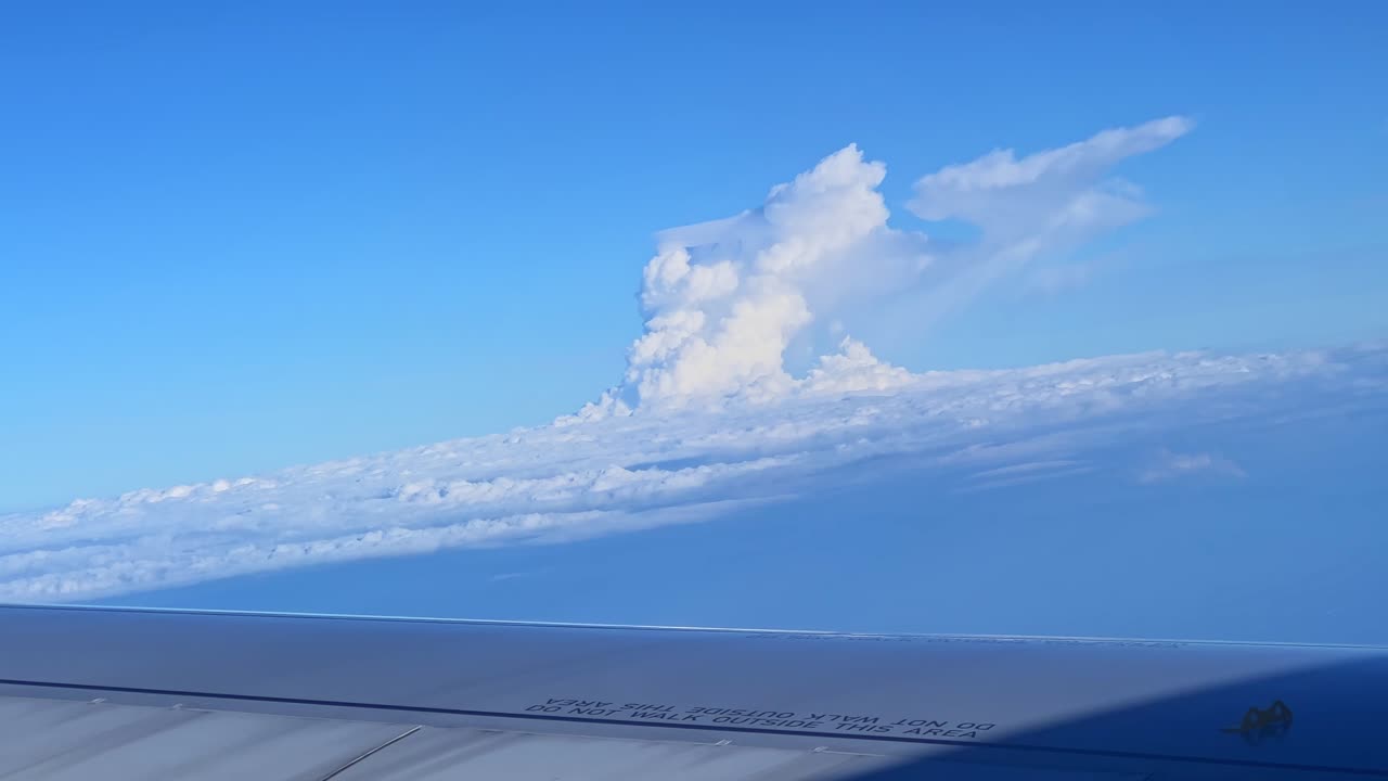 Majestic cumulonimbus cloud formation seen from a jet above the atmosphere—ideal for themes of travel, wonder, nature, and aviation