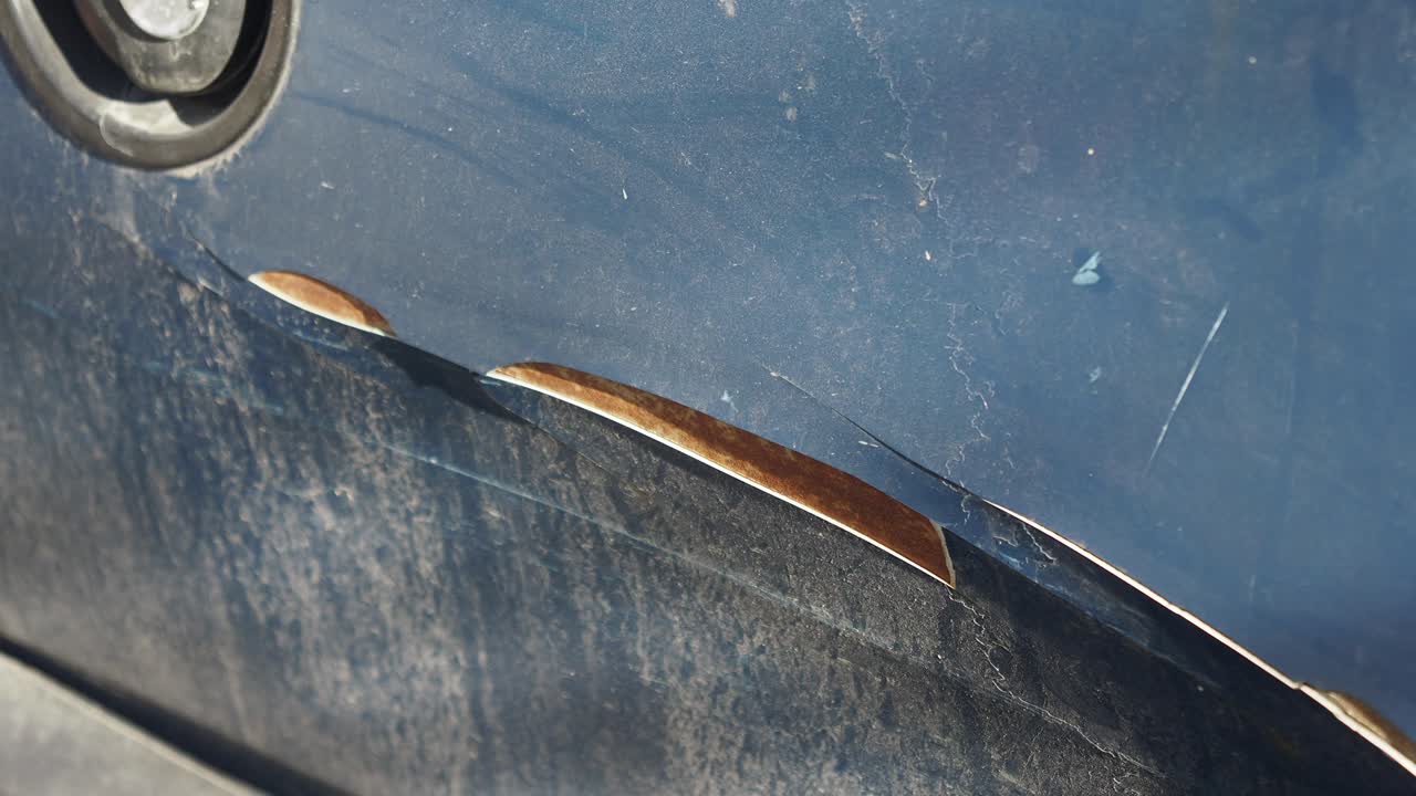 Close-up of car paint damage and rust