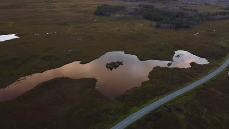 Luftbildlandschaft-über-Der-Skyline-Spiegelt-Sich-Im-Ländlichen-See-Auf-Der-Isle-Of-Skye,-Schottland,-Straße-Durch-Felder