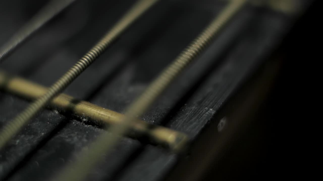 Guitar string vibrating creating wave Macro extreme close up shallow
