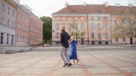 pareja interracial bailando bachata en una plaza pública