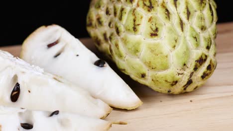 custard apple and slices on wooden board