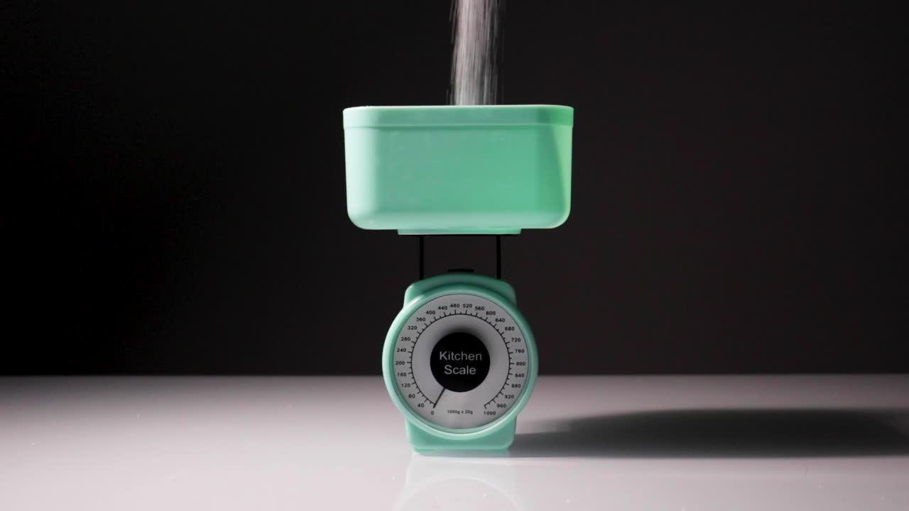 el azúcar se vierte en un juego de escalas, con un peso de 180 g