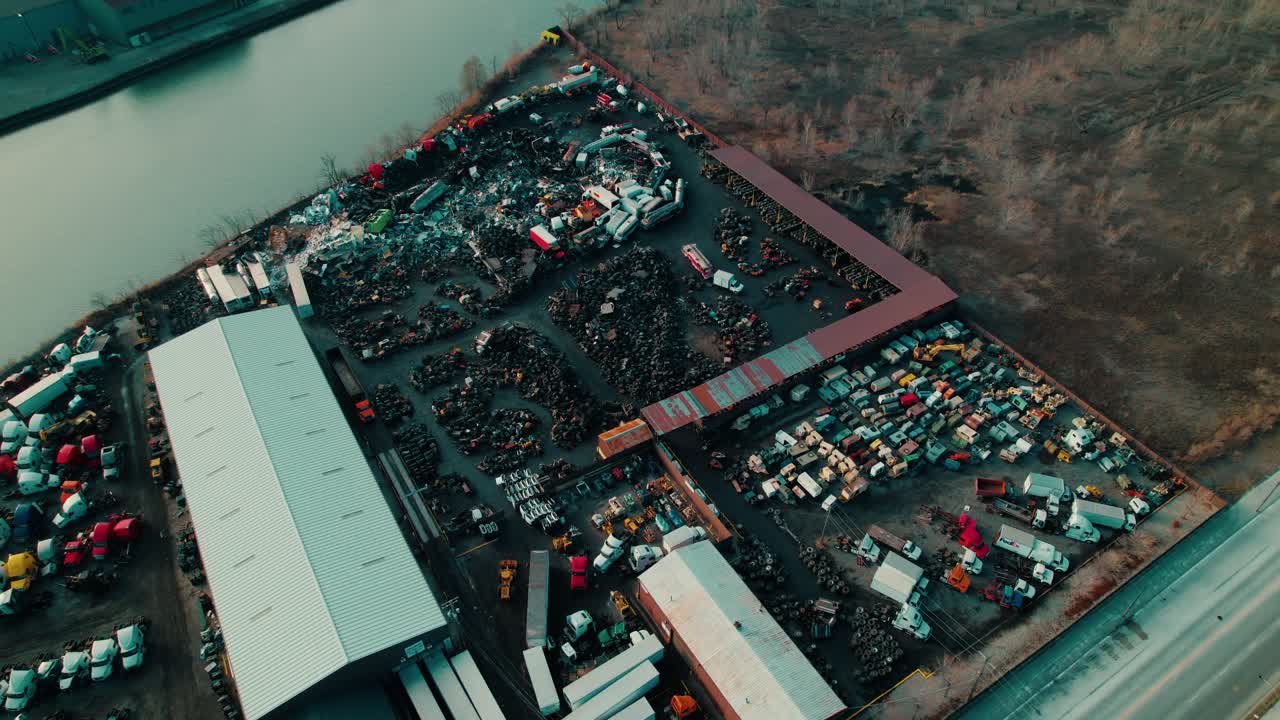 vista aérea de un depósito de chatarra industrial en el sur de chicago, con pilas organizadas de vehículos, maquinaria y equipos cerca de una vía fluvial.