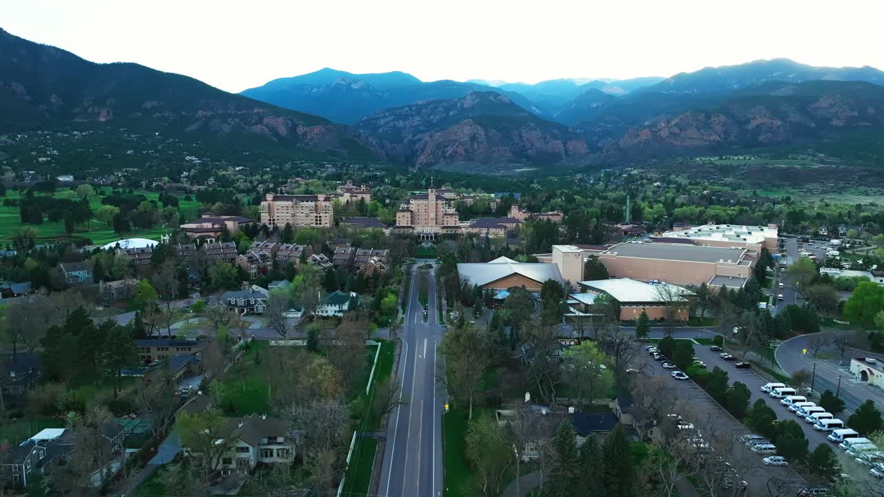 Wide angle of Broadmoor Hotel from distance showing surrounding land and mountainscape