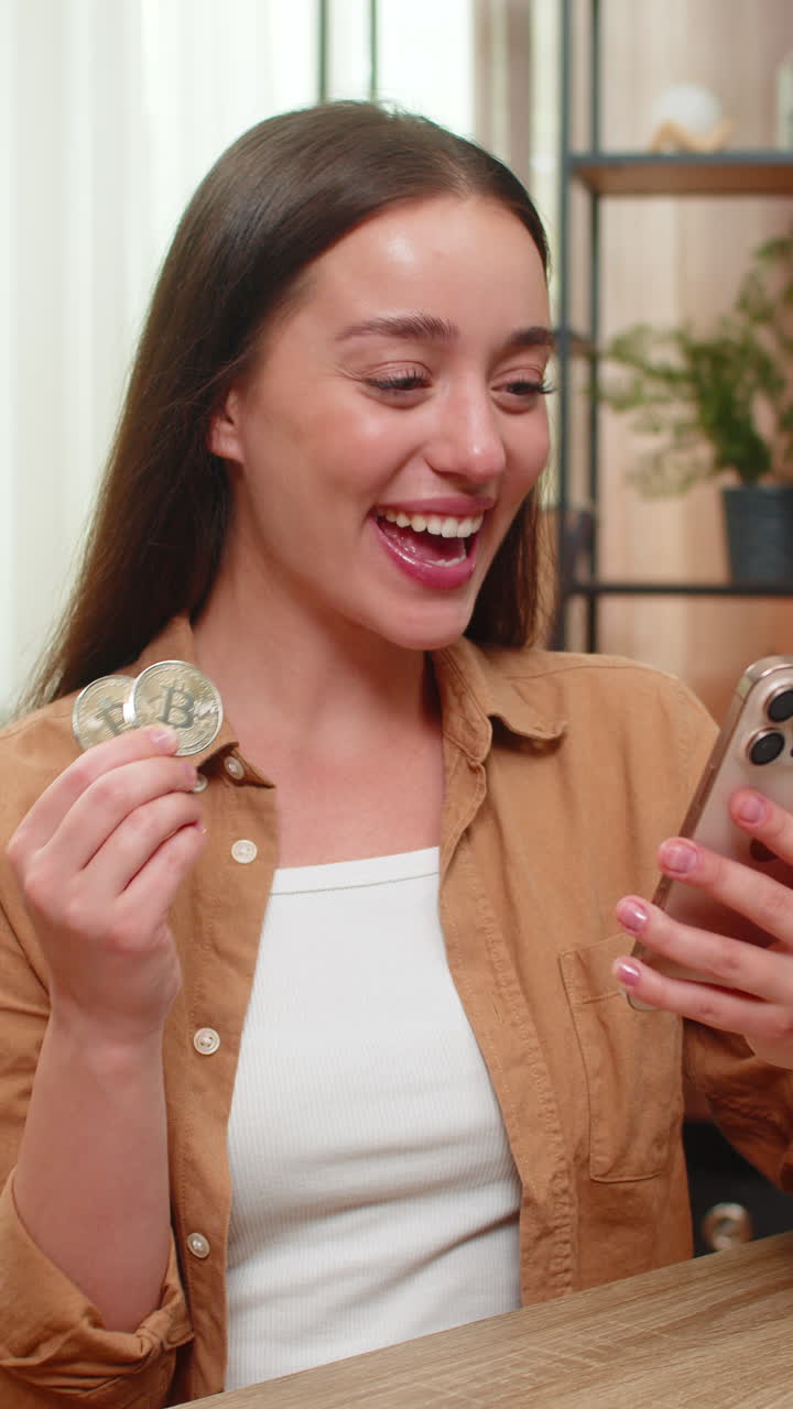 Young woman smiles at smartphone after closing bitcoin trade watching crypto price line with joy now
