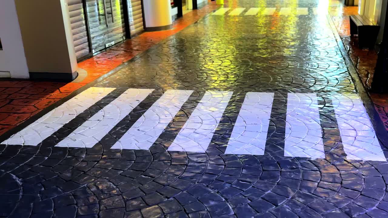 Moody tiled pedestrian crossing with warm reflections—ideal for city scenes, urban design, or cinematic transitions