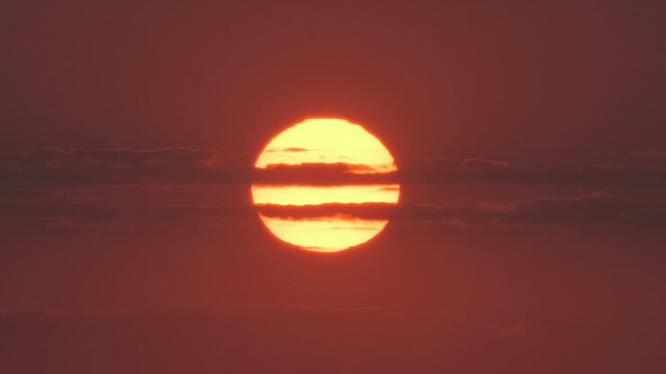 The huge sun and stripe clouds telephoto view
