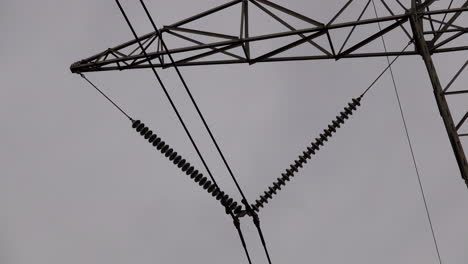 Close-up-of-electrical-insulators-and-transmission-lines-on-electrical-pylon