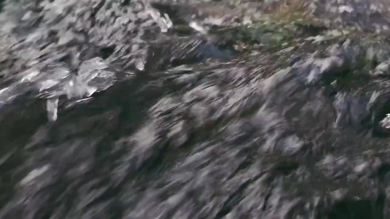 Primo piano dell'acqua impetuosa del fiume che scorre sulle rocce