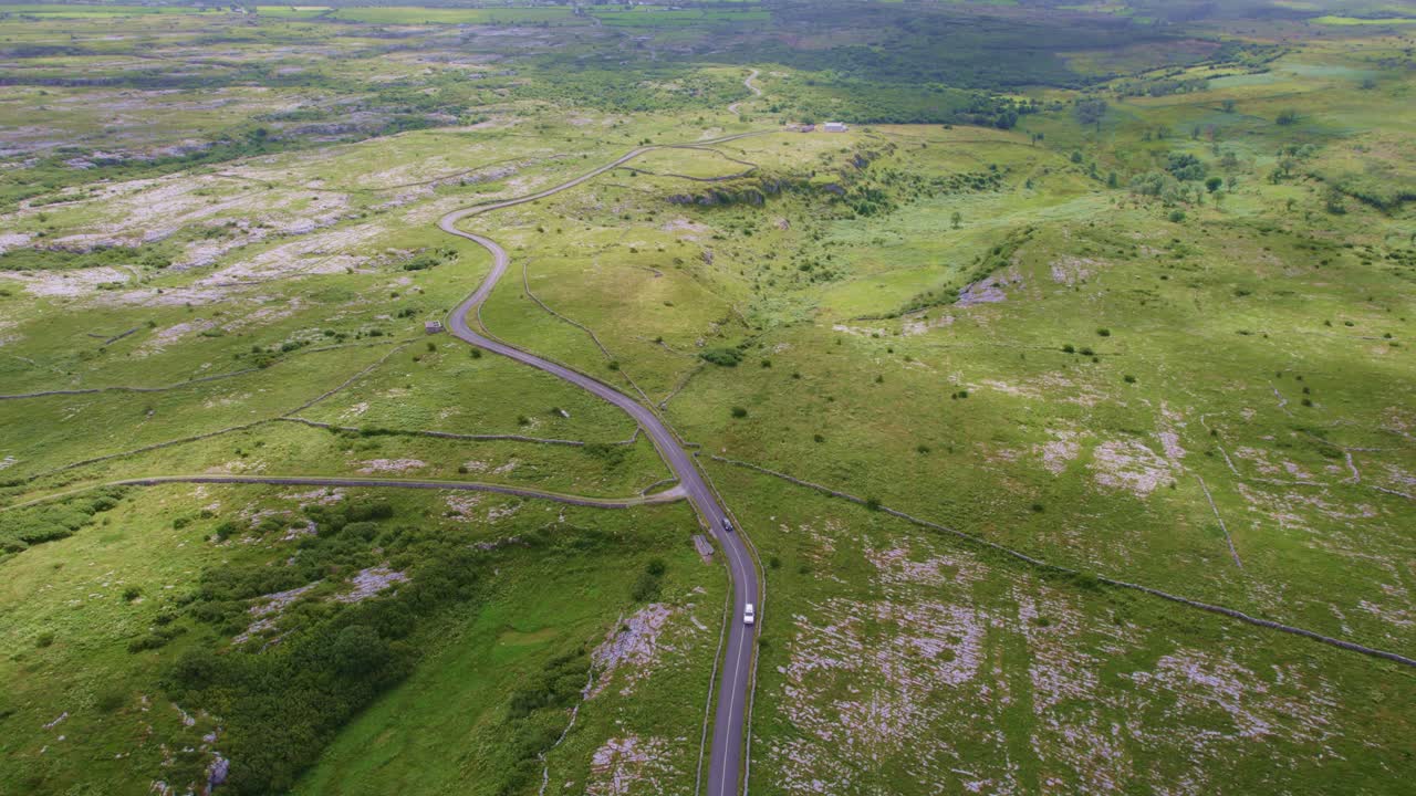 irlanda, un camino serpentea a través de las remotas tierras altas del burren irlanda