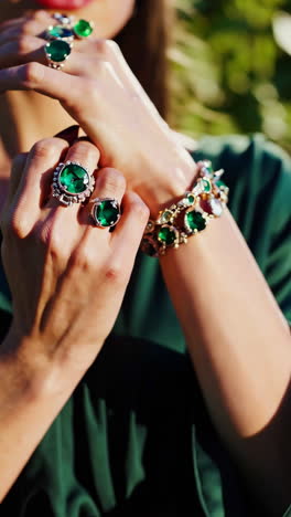 elegant woman adorned with emerald jewelry outdoors