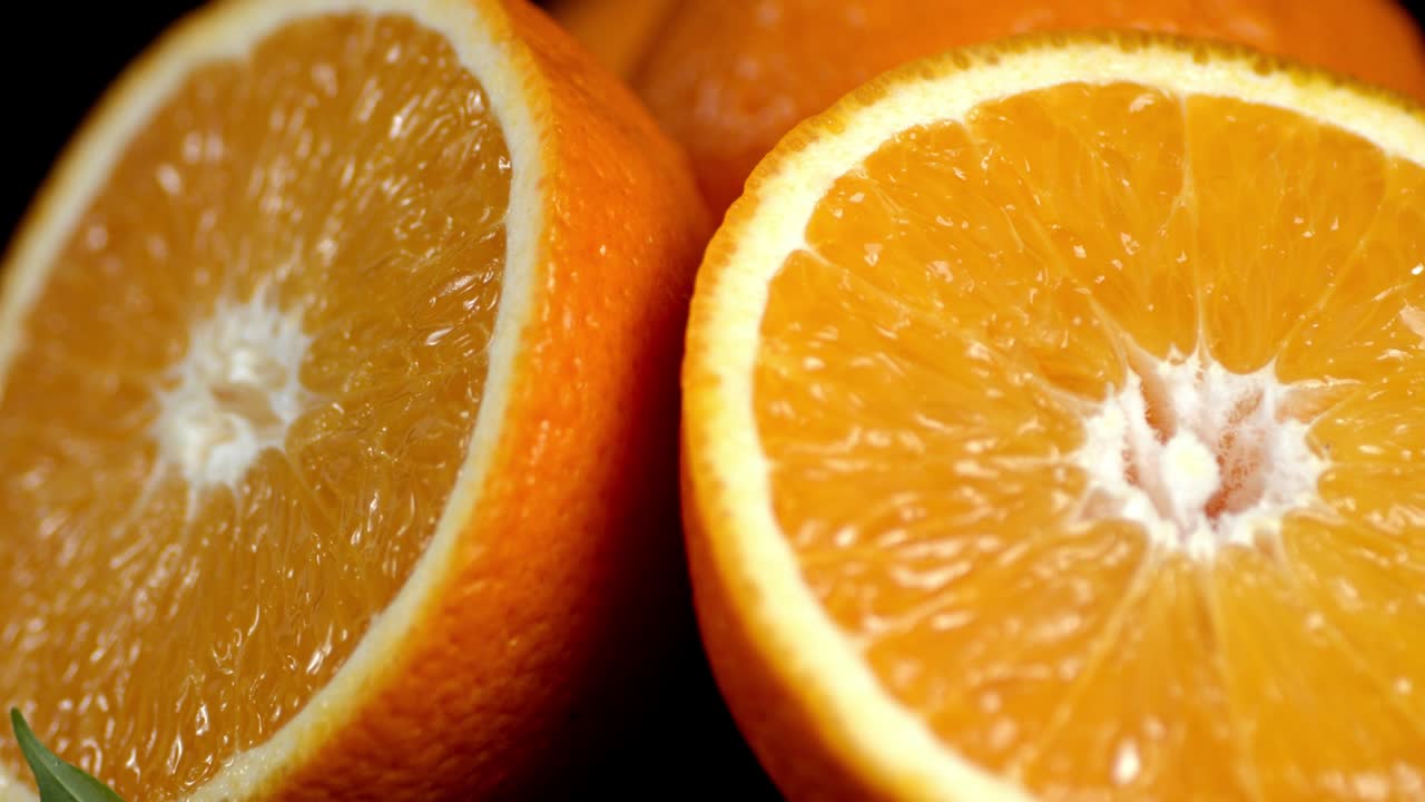 Half of juicy oranges slowly rotate.